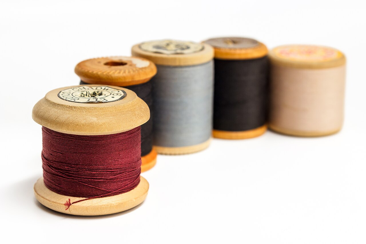 Wooden spools of sewing thread in different colors, an illustrative craft photograph